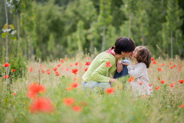 Woman kissing her lovely daughter outdoors