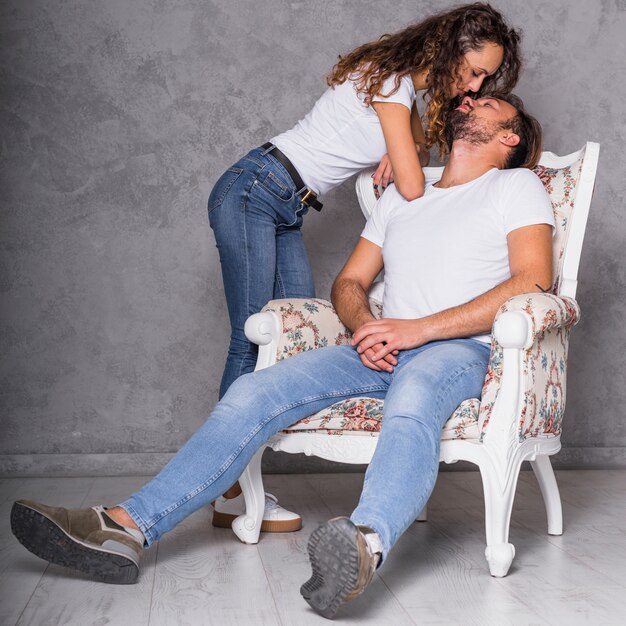 Woman kissing man in armchair 