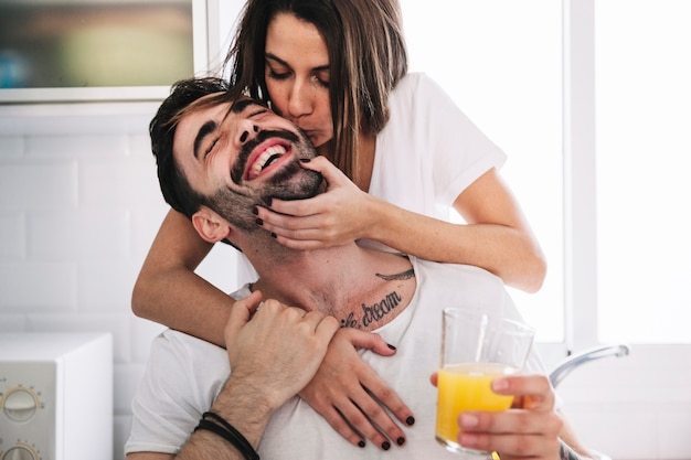 Woman kissing man with juice