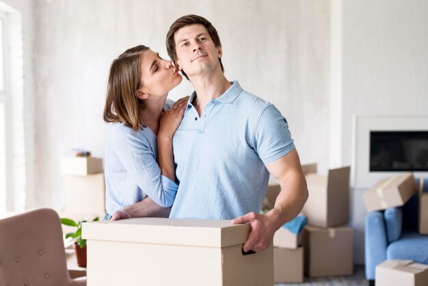 Женщина целует партнера дома в день переезда