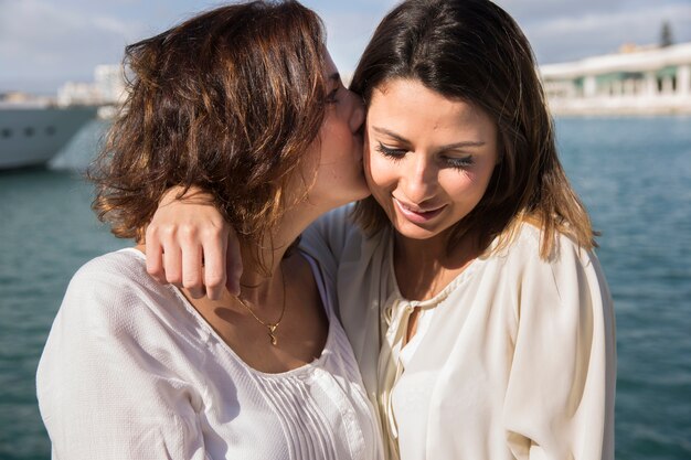 Woman kissing woman in cheek