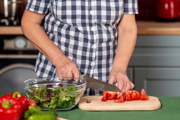 Woman in kitchen cooking salad