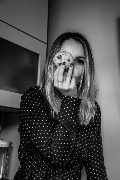 Woman in kitchen holding cookie