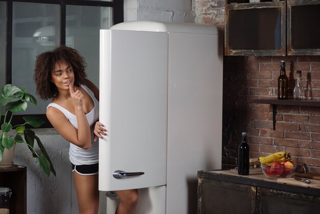 Woman in kitchen looking into fridge