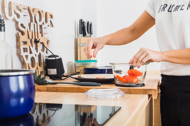 Foto gratuita donna in cucina a mettere i pomodori nel frullatore