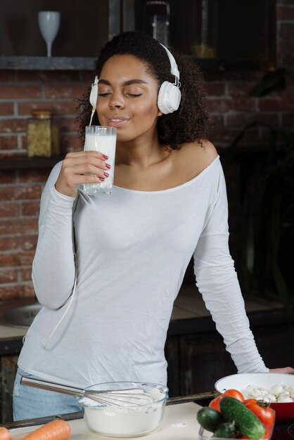 Woman in kitchen smelling on milk