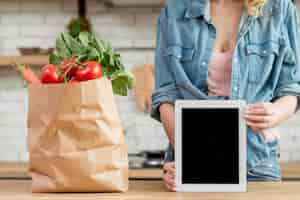 Foto gratuita donna in cucina con un tablet