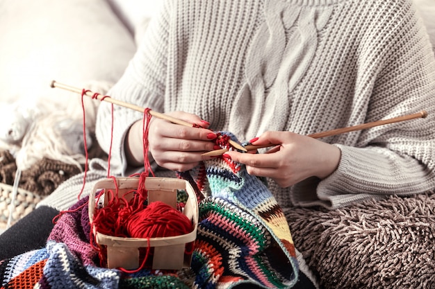 woman knits knitting needles on the couch