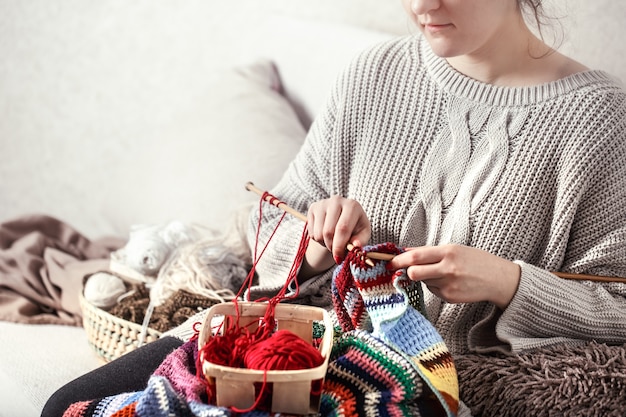 woman knits knitting needles on the couch