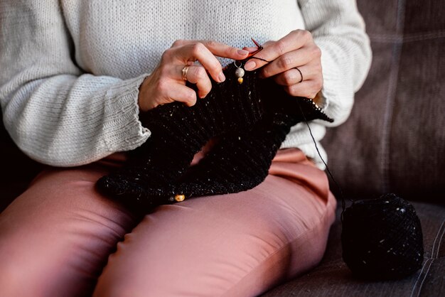 黒糸アクセサリーを編む女性