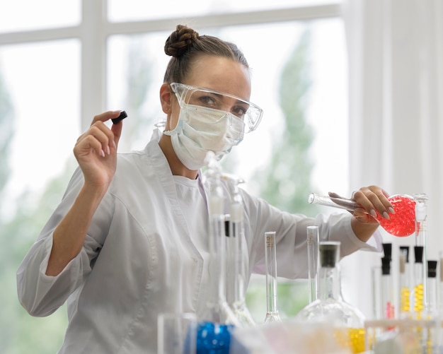 Foto gratuita donna in laboratorio facendo esperimenti