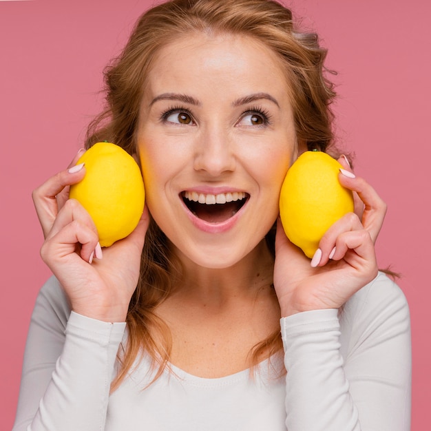 Женщина смеется, холдинг лимоны