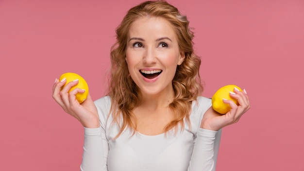 Женщина смеется, холдинг лимоны