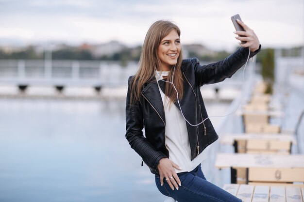 Woman laughing leaning on a railing making an auto photo