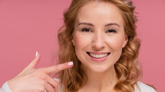 Free photo woman laughing pointing at her smile