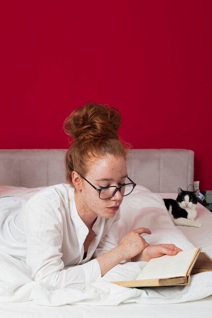 고양이 독서와 함께 침대에 누워 여자