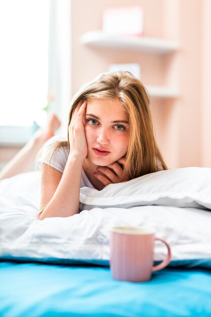 Woman laying in bed looking at camera