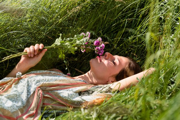 Женщина лежит на траве, вид сбоку