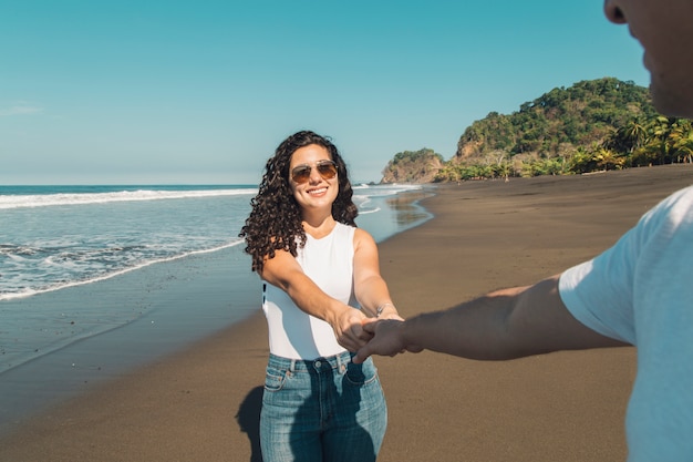 Foto gratuita donna che porta l'uomo sulla spiaggia