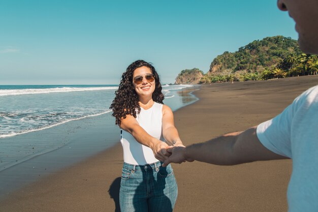 Woman leading man on beach