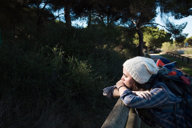 Woman leaning on fence in nature