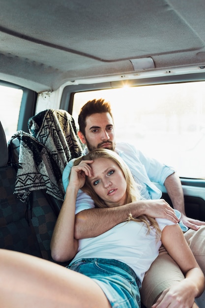 Woman leaning on man in car