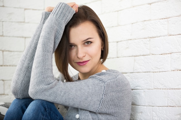 Free photo woman leaning on wall looking at the camara