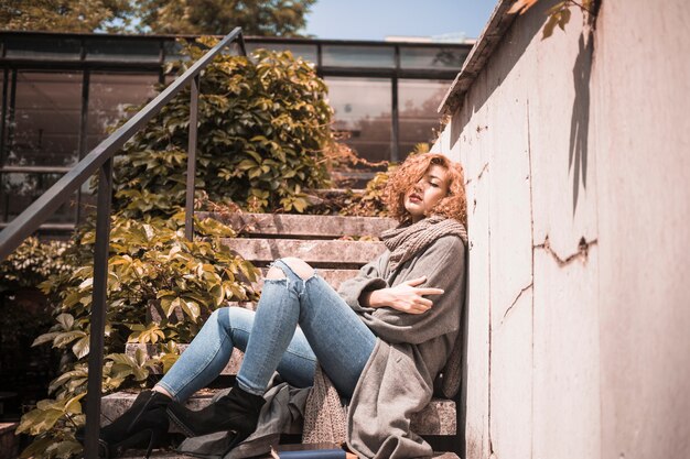 Woman leaning on wall near steps 