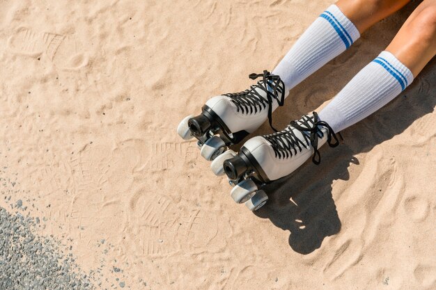 Woman legs in socks and skates on sand