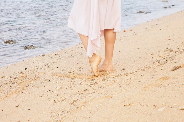 ビーチの砂の上を歩く女性の足