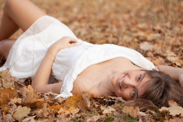 woman lies in oak leaves