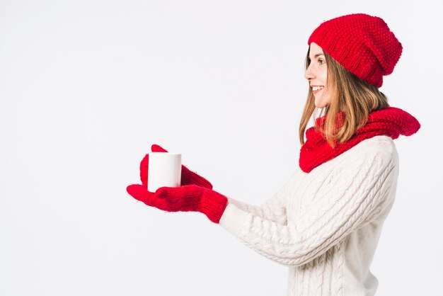 Woman in light sweater holding cup