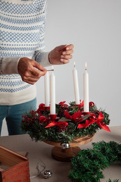 Woman lighting wreath candle on fire