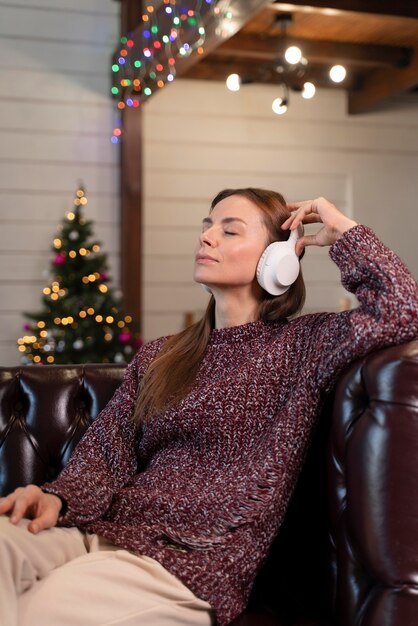 ヘッドフォンでクリスマス音楽を聴いている女性