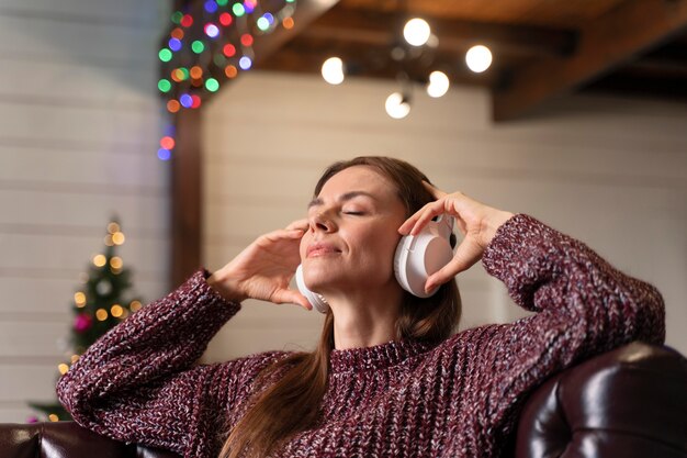 ヘッドフォンでクリスマス音楽を聴いている女性