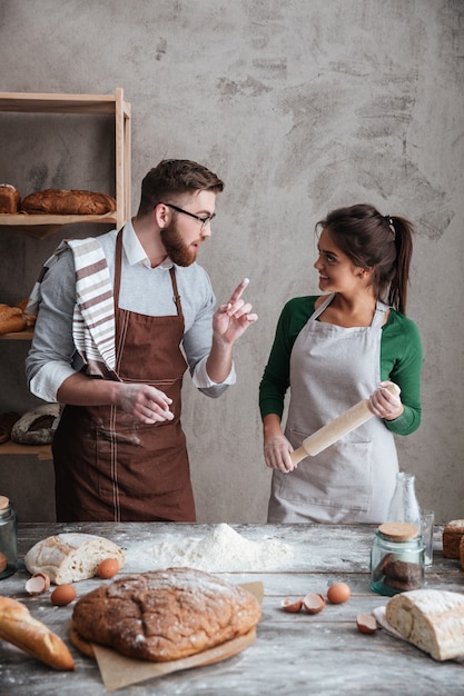 A woman listening the instructions of a man about baking bread