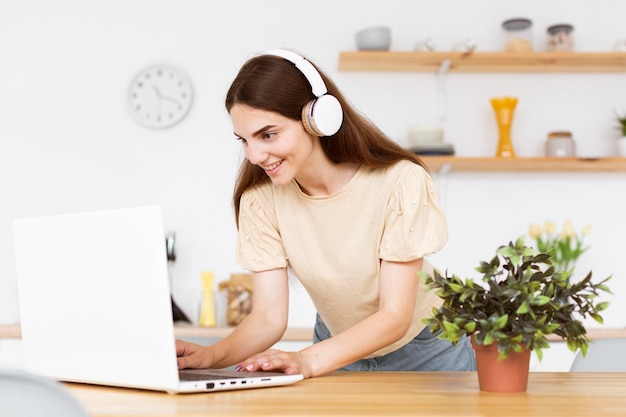 Foto gratuita donna che ascolta musica dal suo computer portatile