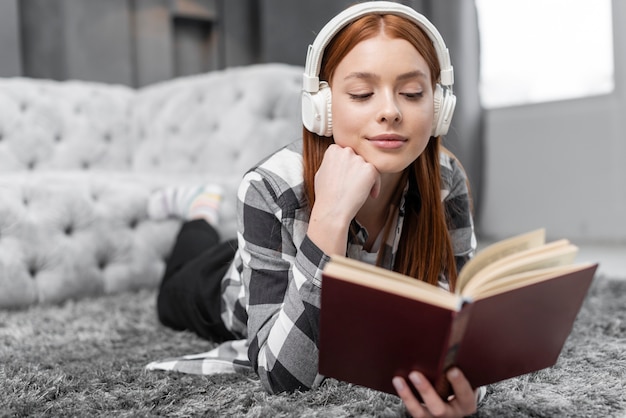 Woman listening to music and reading
