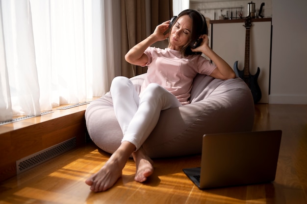 woman listening to music through headphones at home