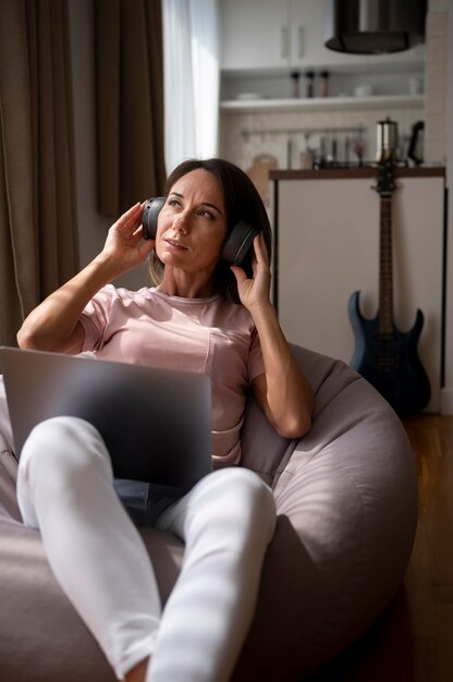 woman listening to music through headphones at home