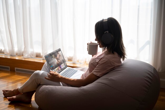 Woman listening to music through headphones at home