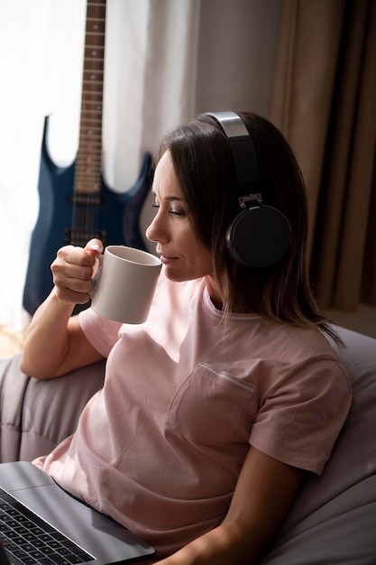 Woman listening to music through headphones at home