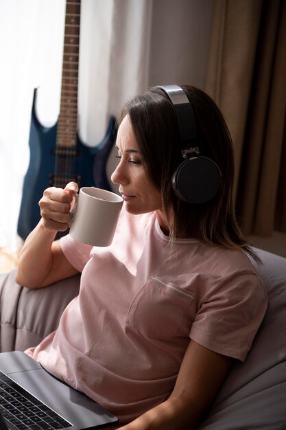 woman listening to music through headphones at home
