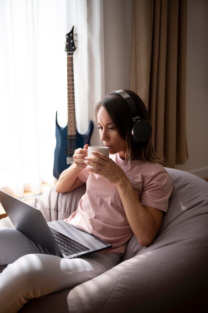 woman listening to music through headphones at home