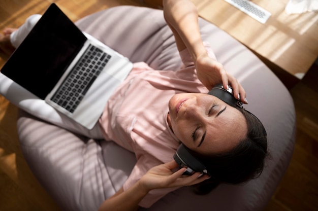 woman listening to music through headphones at home