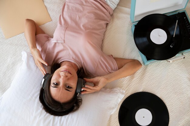 Woman listening to music through headphones at home