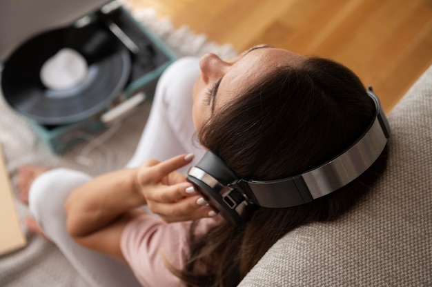 Woman listening to music through headphones at home