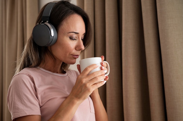 woman listening to music through headphones at home