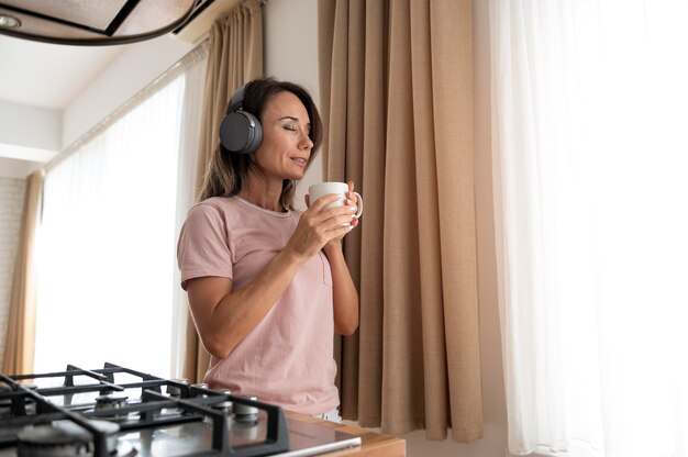woman listening to music through headphones at home