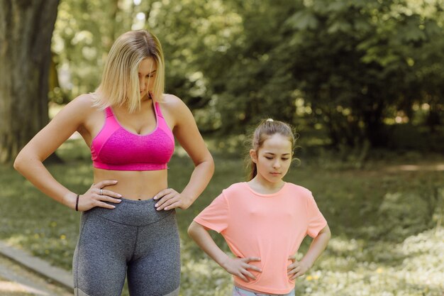 Woman and little girl do excercises outside